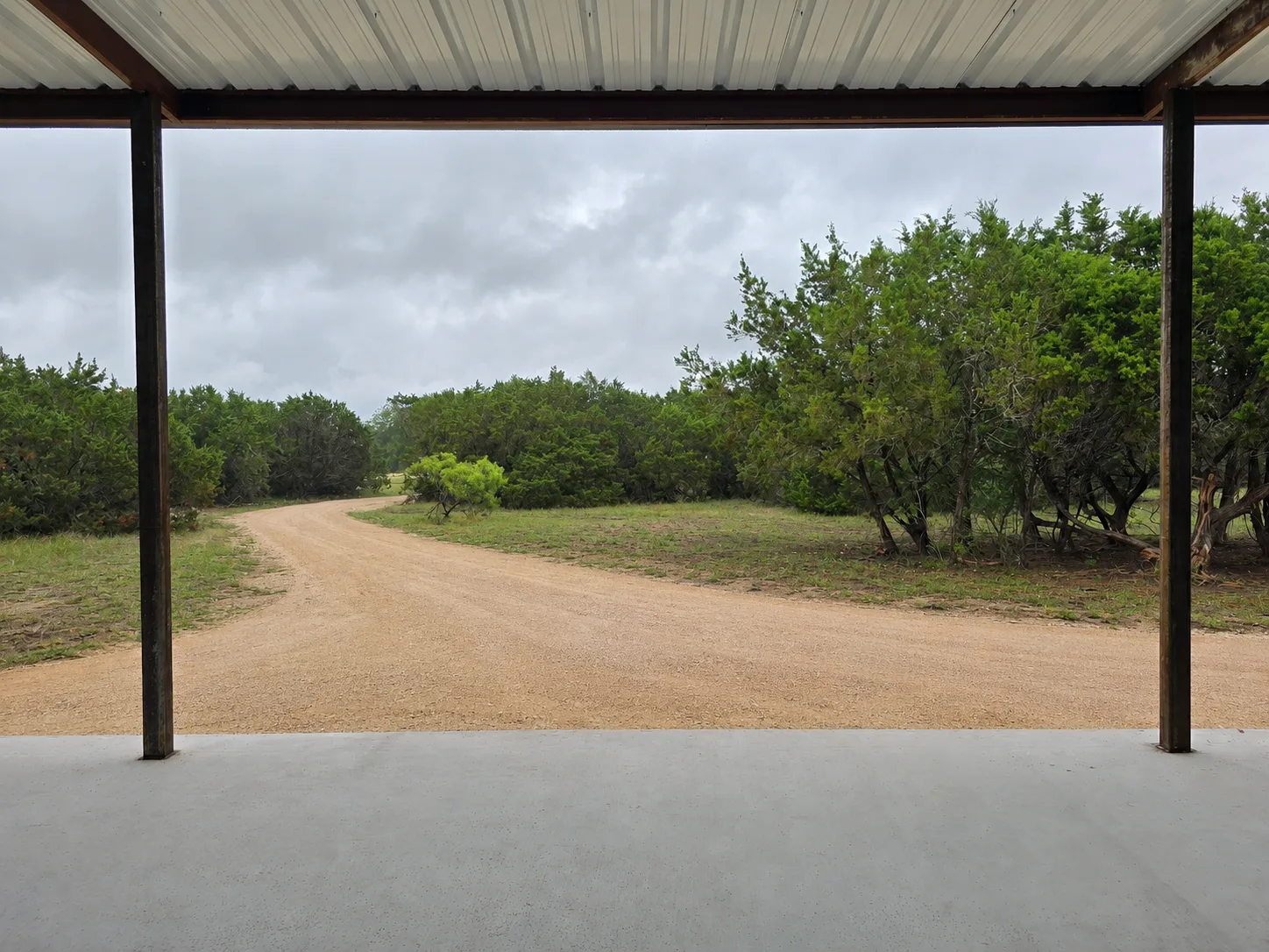 Covered porch of the barndo shell looking down the granite gravel road